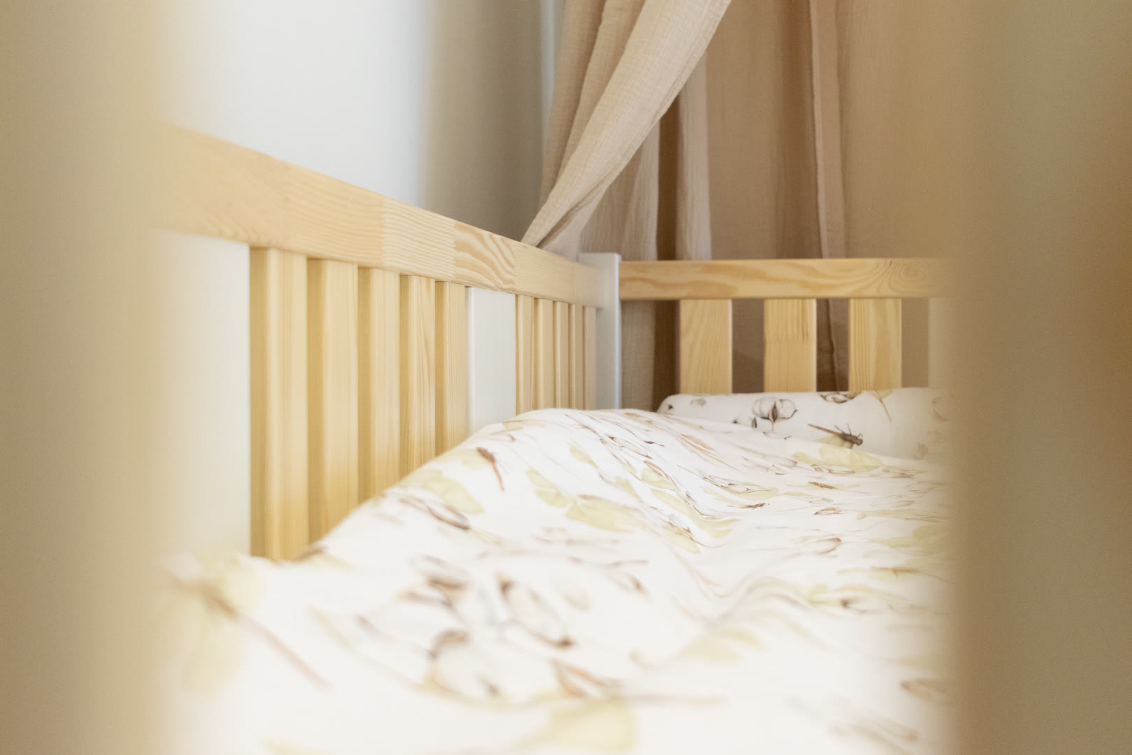 Łóżko dziecięce z drewna sosnowego przy ścianie w małym pokoju około ośmiu metrów